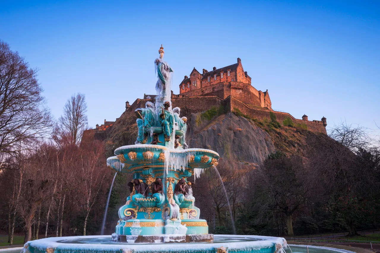 A frozen Ross Fountain with Edinburgh Castle from Princes Street Gardens